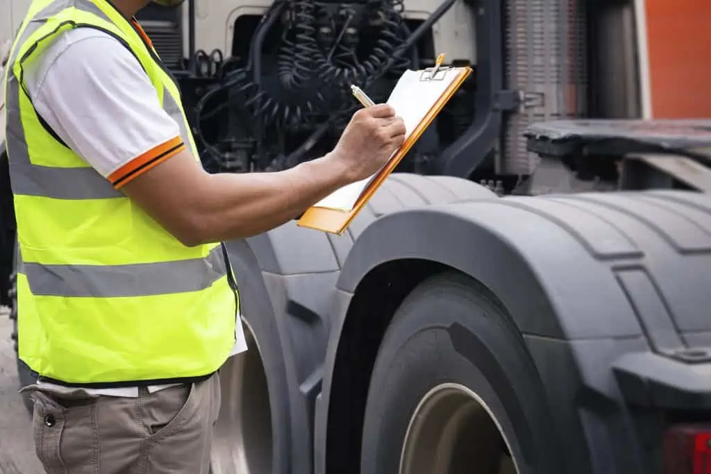 auto-mechanic-holding-clipboard-checking-maintenance-program-semi-truck-truck-inspection-safety-driving