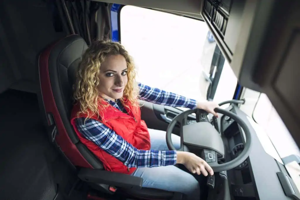 Woman trucker sitting in truck vehicle.