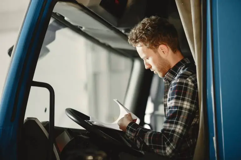 Driver of blue truck and a plaid shirt reviewing compensation analysis