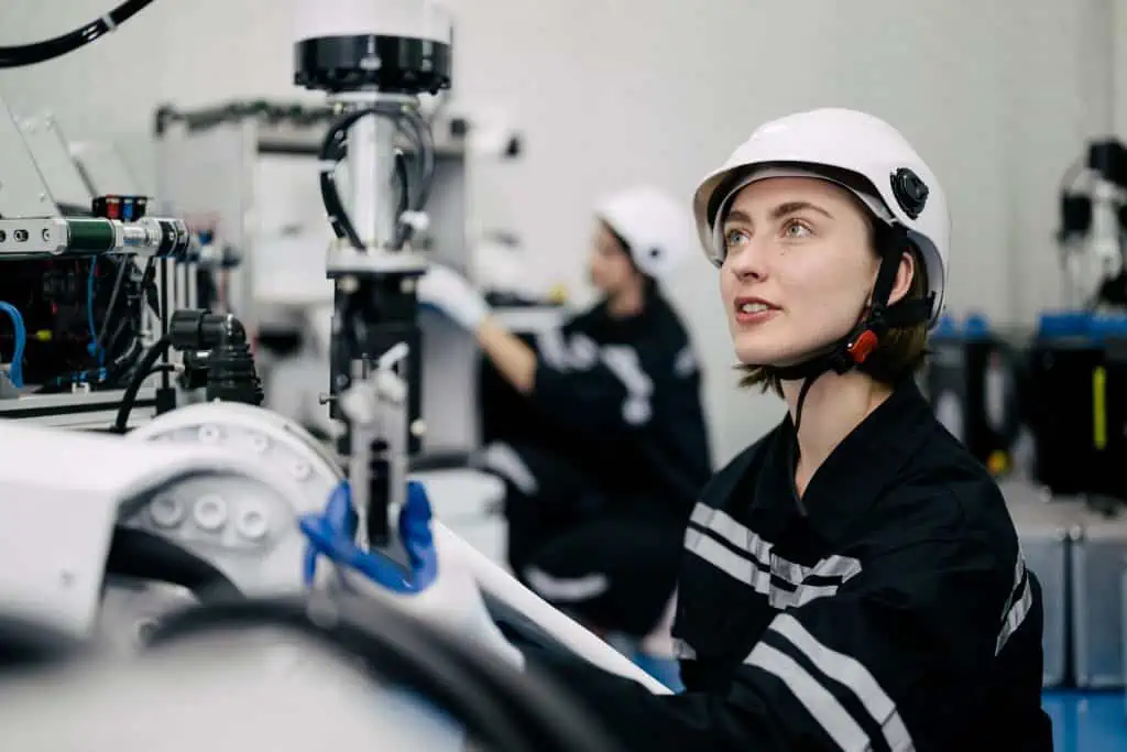 Smiling portrait of female technician engineer checking and repairing automatic machine at manufacturing automation factory, Technology and innovation concept