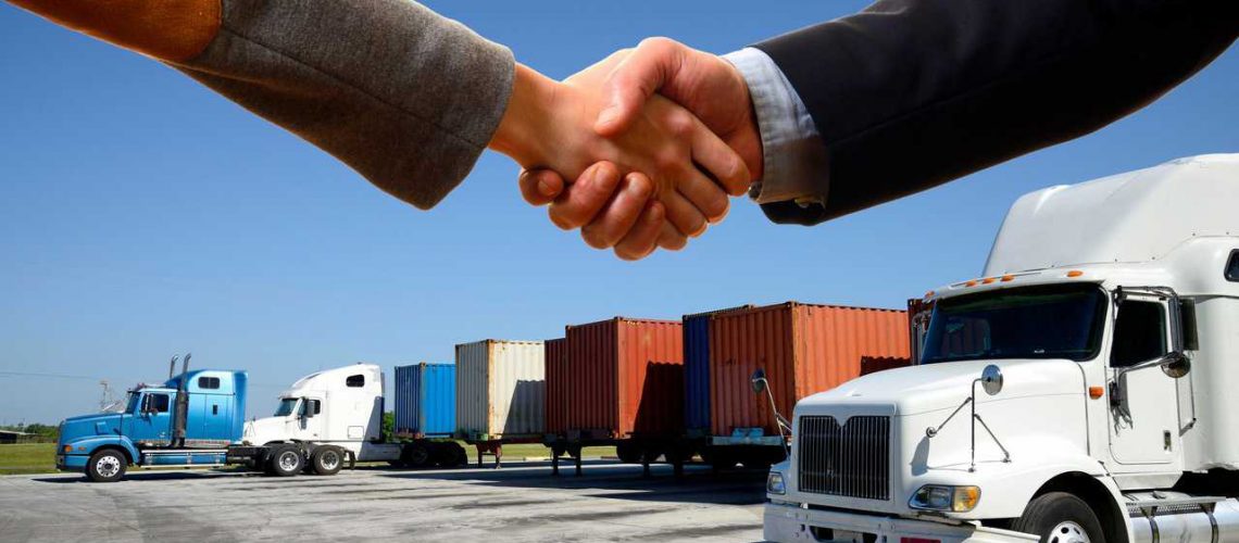 Handshake with semi trucks in background